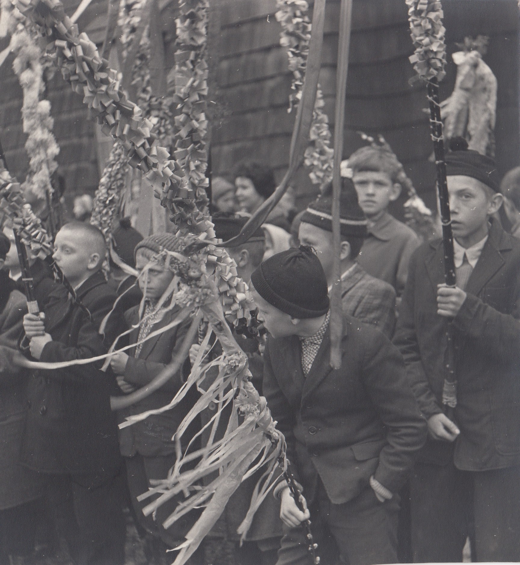 czarnobiałe zdjęcie - grupka chłopców trzyma palmy do prezentacji w czasie konkursu